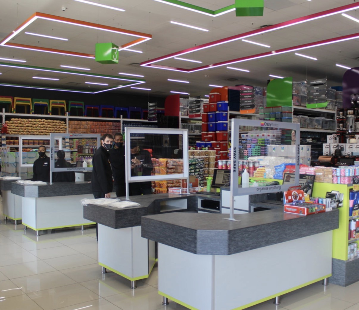 Retail store checkout area with white linear ceiling lights and colourful rectangular feature lighting